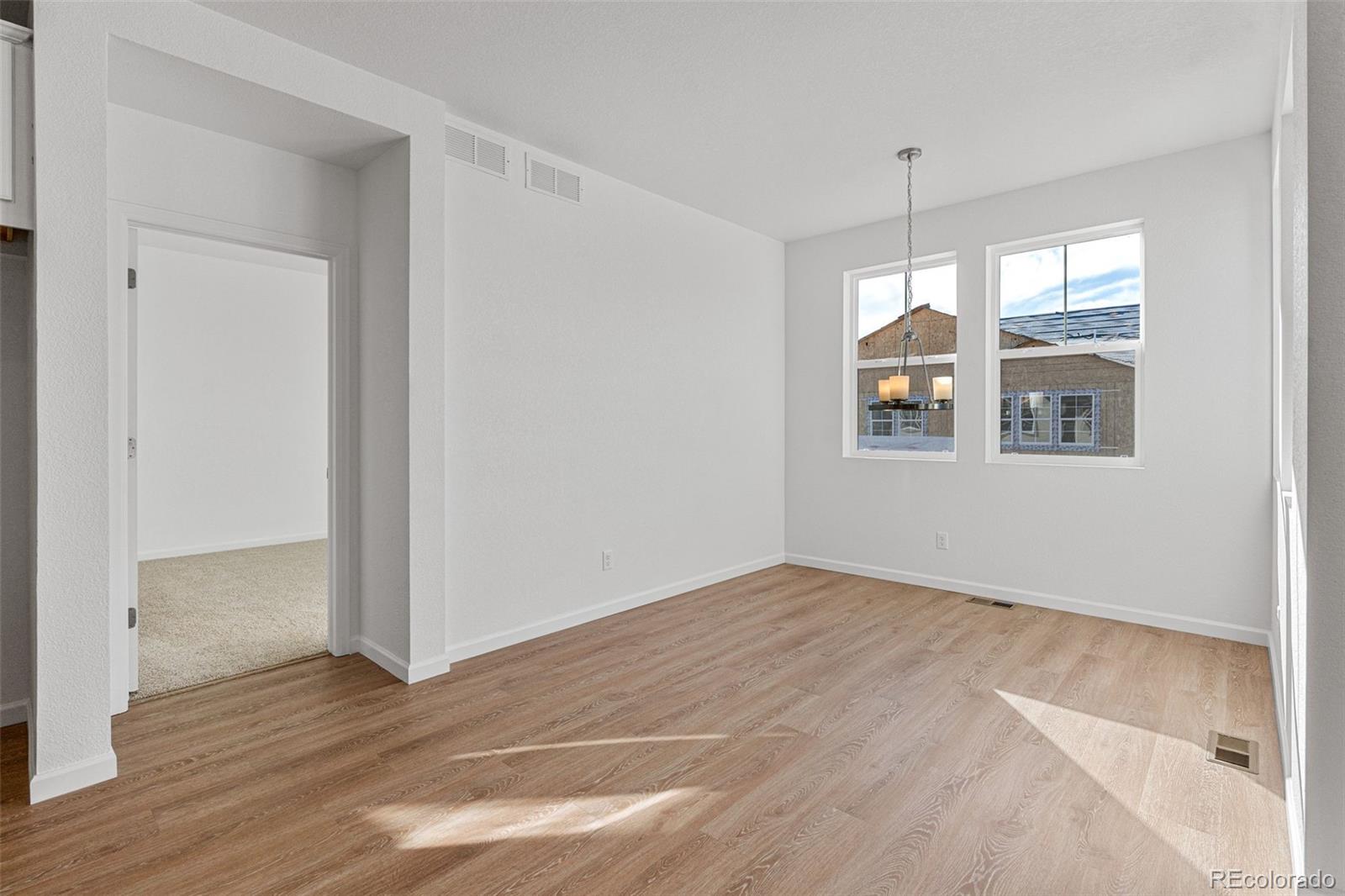 23966 E River Aurora, CO 80019 - Photo 11 of 50 an empty room with wooden floor and windows