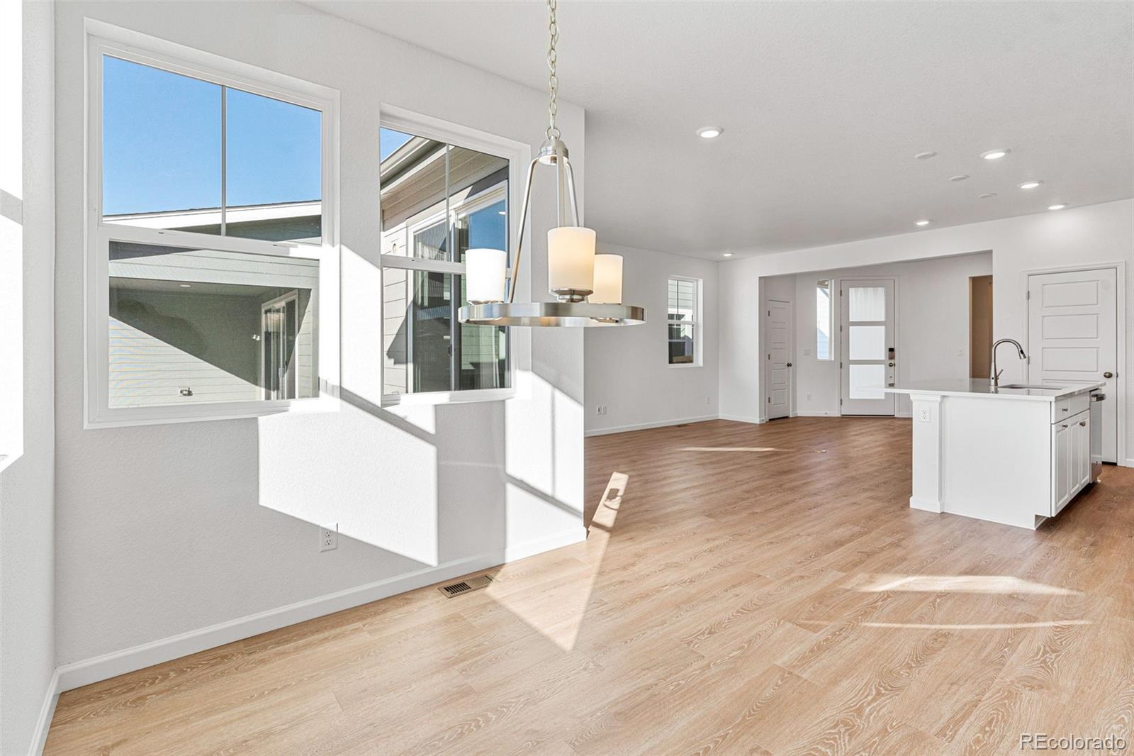 23966 E River Aurora, CO 80019 - Photo 13 of 50 a view of a kitchen with kitchen island granite countertop wooden floor and white cabinets