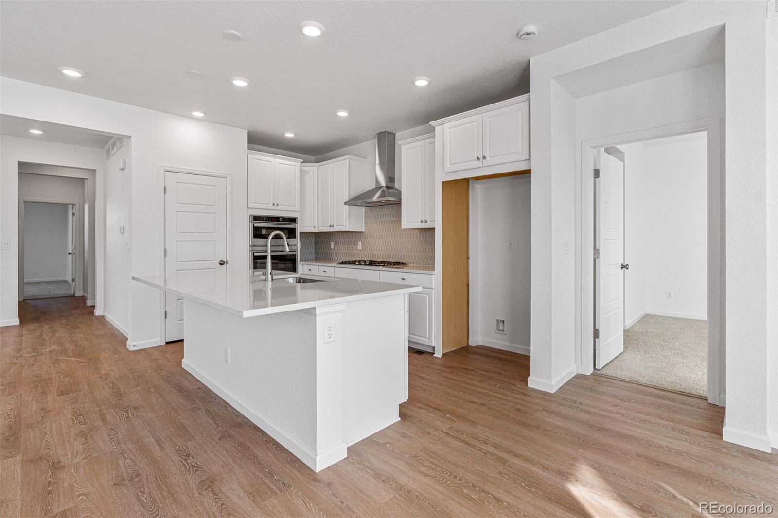 23966 E River Aurora, CO 80019 - Photo 14 of 50 a kitchen with white cabinets and stainless steel appliances