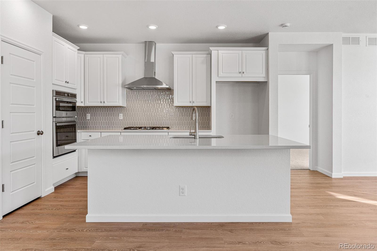 23966 E River Aurora, CO 80019 - Photo 16 of 50 a kitchen with stainless steel appliances granite countertop a sink a stove a refrigerator and white cabinets