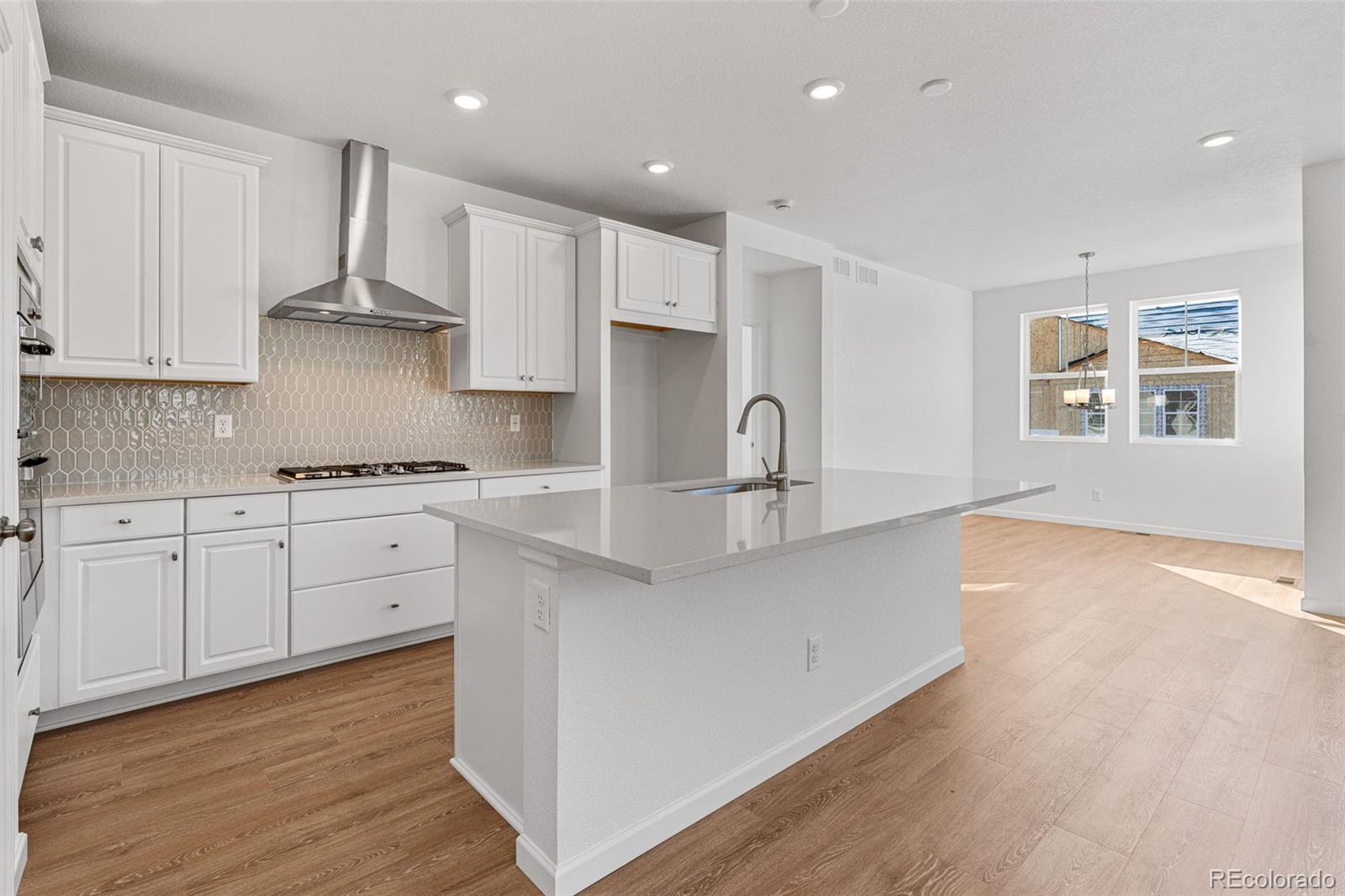 23966 E River Aurora, CO 80019 - Photo 17 of 50 a kitchen with stainless steel appliances granite countertop a sink a stove a refrigerator and white cabinets with wooden floor