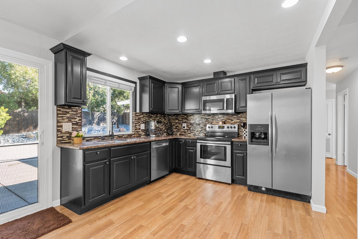 6321 Paco Court Citrus Heights, CA 95621 - Photo 11 of 36 a kitchen with stainless steel appliances granite countertop a refrigerator a sink a stove top oven a refrigerator with wooden floor and cabinets