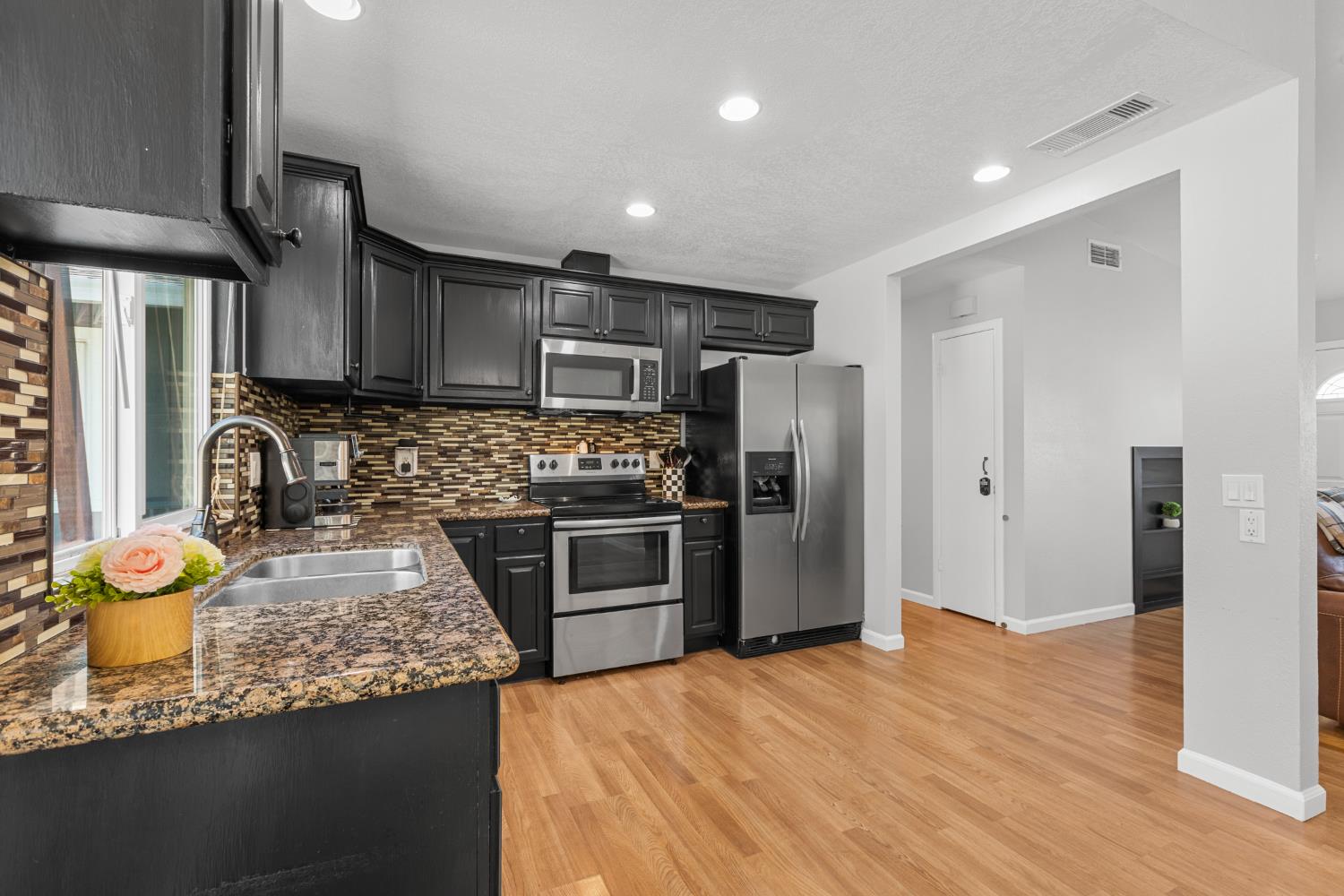 6321 Paco Court Citrus Heights, CA 95621 - Photo 13 of 36 a kitchen with granite countertop stainless steel appliances a sink stove refrigerator and wooden floor