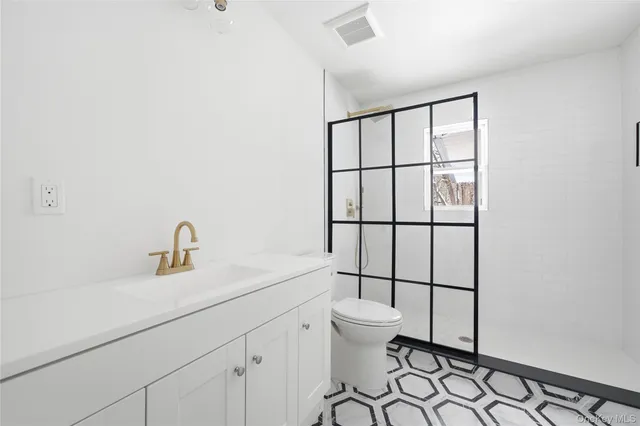 a bathroom with a toilet sink vanity and window