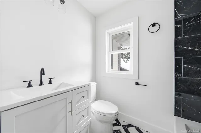 a bathroom with a sink toilet and a mirror