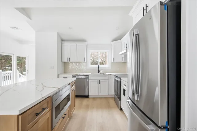 a kitchen with a sink cabinets stainless steel appliances and a window