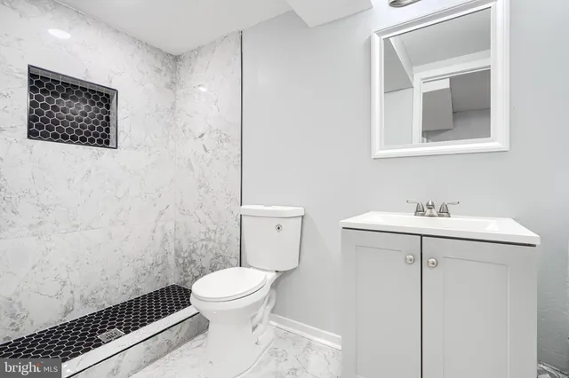 a bathroom with a toilet a sink and mirror