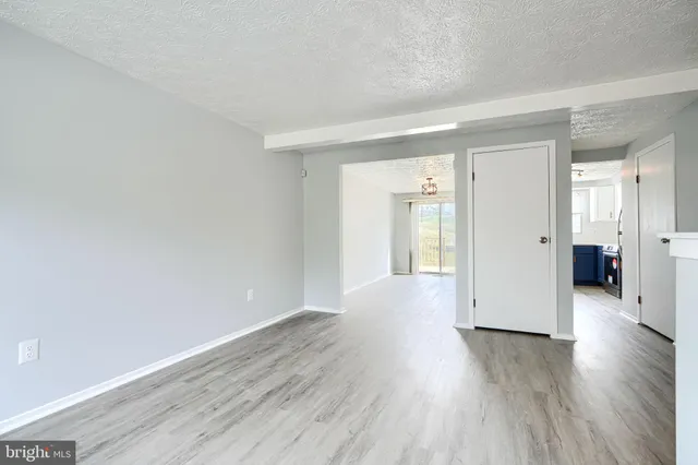 a view of a big room with wooden floor and windows