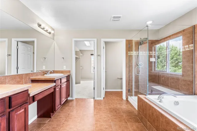 a spacious bathroom with a tub sink shower and mirror