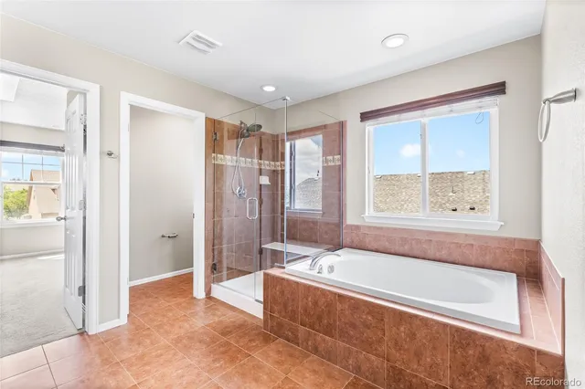 a spacious bathroom with a tub shower and sink