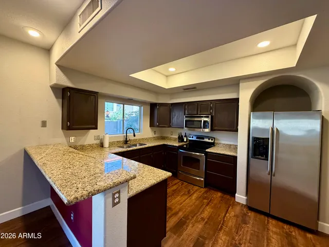 a kitchen with granite countertop stainless steel appliances and sink