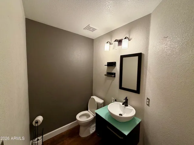 a bathroom with a toilet sink vanity and mirror
