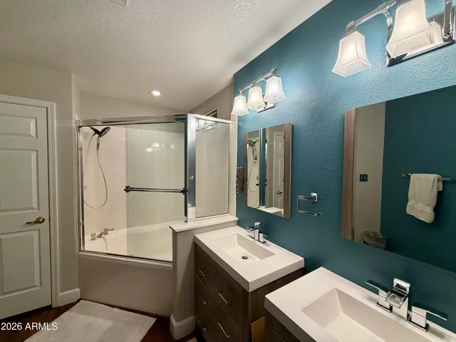 a bathroom with a tub sink and mirror