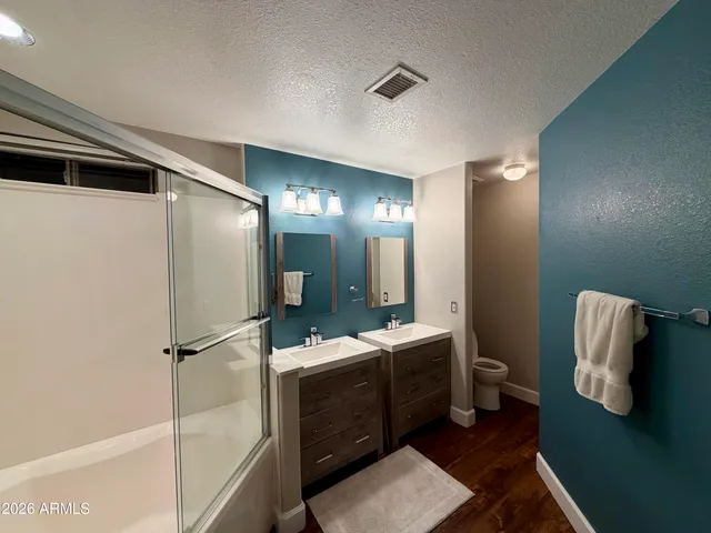 a bathroom with a sink a toilet and shower