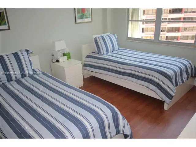 a bedroom with a bed and a flat tv screen on the dresser