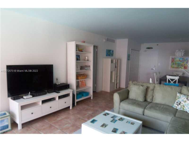 5161 Collins Avenue, Unit 902 Miami Beach, FL 33140 - Photo 6 of 43 a living room with furniture and a flat screen tv