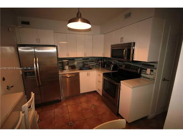 a kitchen with a refrigerator and a stove top oven