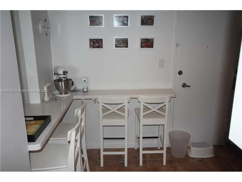 5161 Collins Avenue, Unit 902 Miami Beach, FL 33140 - Photo 10 of 43 a kitchen with a table and chairs