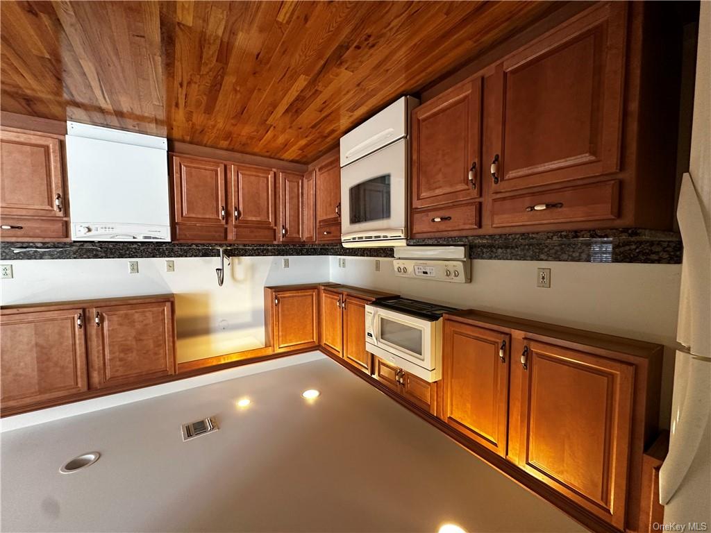 105 South Montgomery Street, Unit B1 4 Walden, NY 12586 - Photo 3 of 20 Kitchen with dark hardwood / wood-style floors, dark stone counters, and white appliances