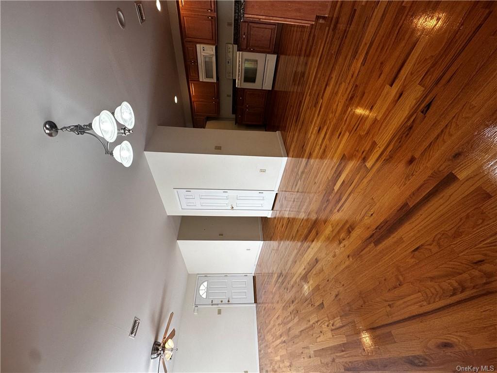 105 South Montgomery Street, Unit B1 4 Walden, NY 12586 - Photo 8 of 20 Unfurnished living room featuring ceiling fan with notable chandelier and dark hardwood / wood-style flooring