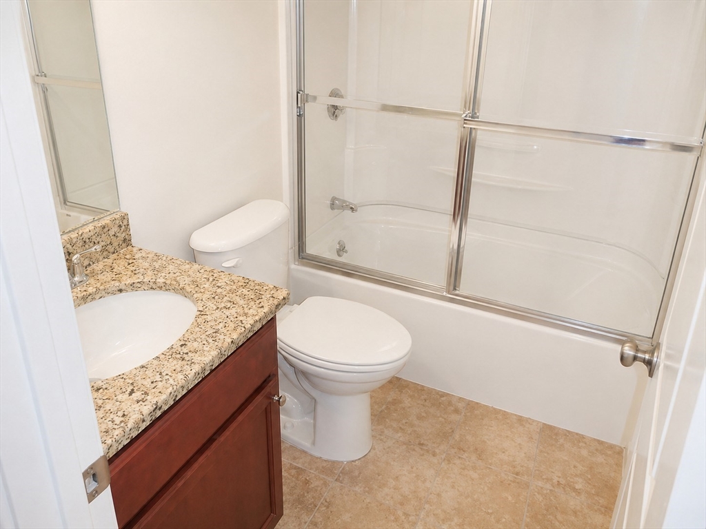 92 Sandwich Road, Unit 4D Bourne, MA 02532 - Photo 13 of 18 a bathroom with a granite countertop sink toilet and shower