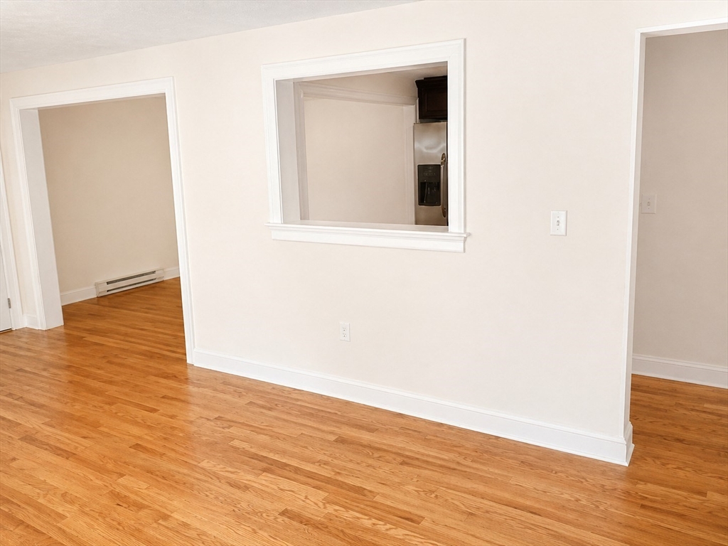 92 Sandwich Road, Unit 4D Bourne, MA 02532 - Photo 17 of 18 an empty room with wooden floor and windows