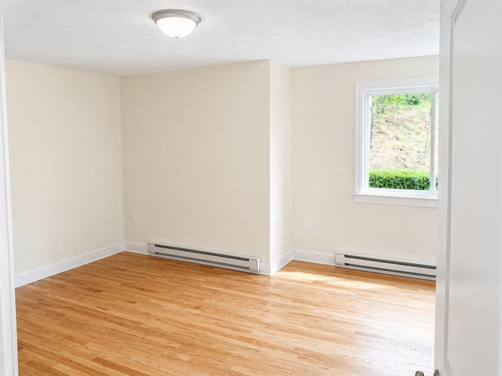 92 Sandwich Road, Unit 4D Bourne, MA 02532 - Photo 8 of 18 an empty room with wooden floor and windows