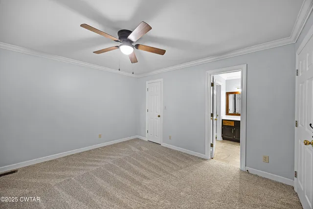 a view of an empty room with chandelier fan