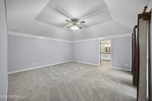 a view of an empty room and a ceiling fan