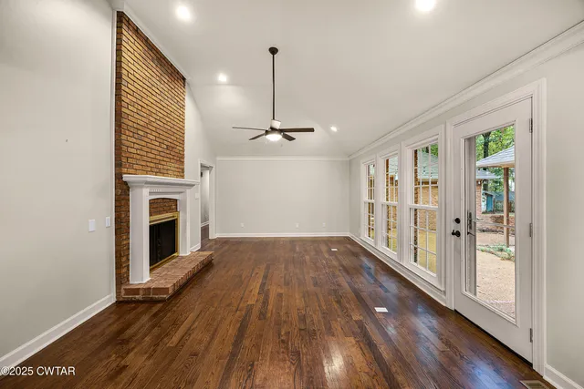 a view of empty room with wooden floor and fireplace