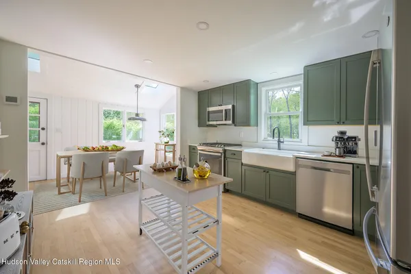 a kitchen with a dining table chairs and white appliances