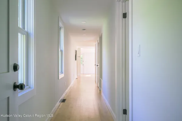 a view of a hallway with wooden floor and closet