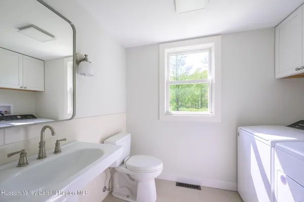a bathroom with a toilet sink and mirror