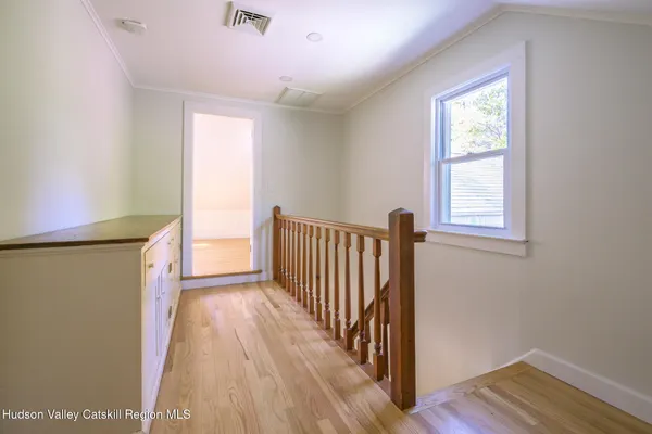 a view of a hallway with wooden floor and closet