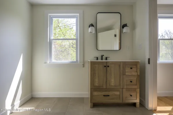 a bathroom with a granite countertop sink a mirror and a window