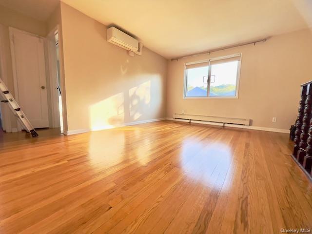 216-37 68th Avenue, Unit 2 Queens, NY 11364 - Photo 3 of 27 a view of an empty room with wooden floor and a window