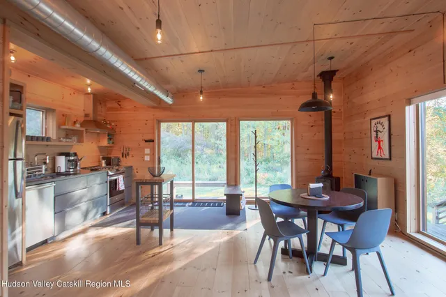 a living room with furniture a flat screen tv and a floor to ceiling window