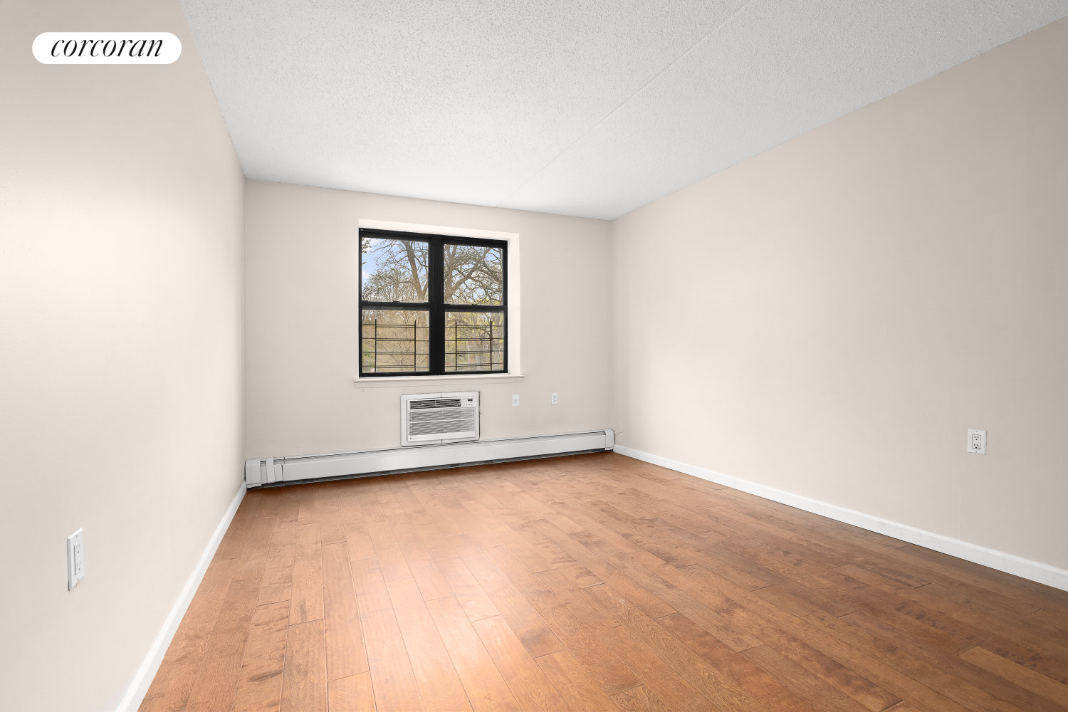 1901 Madison Avenue, Unit 218 Manhattan, NY 10035 - Photo 12 of 13 an empty room with wooden floor and windows