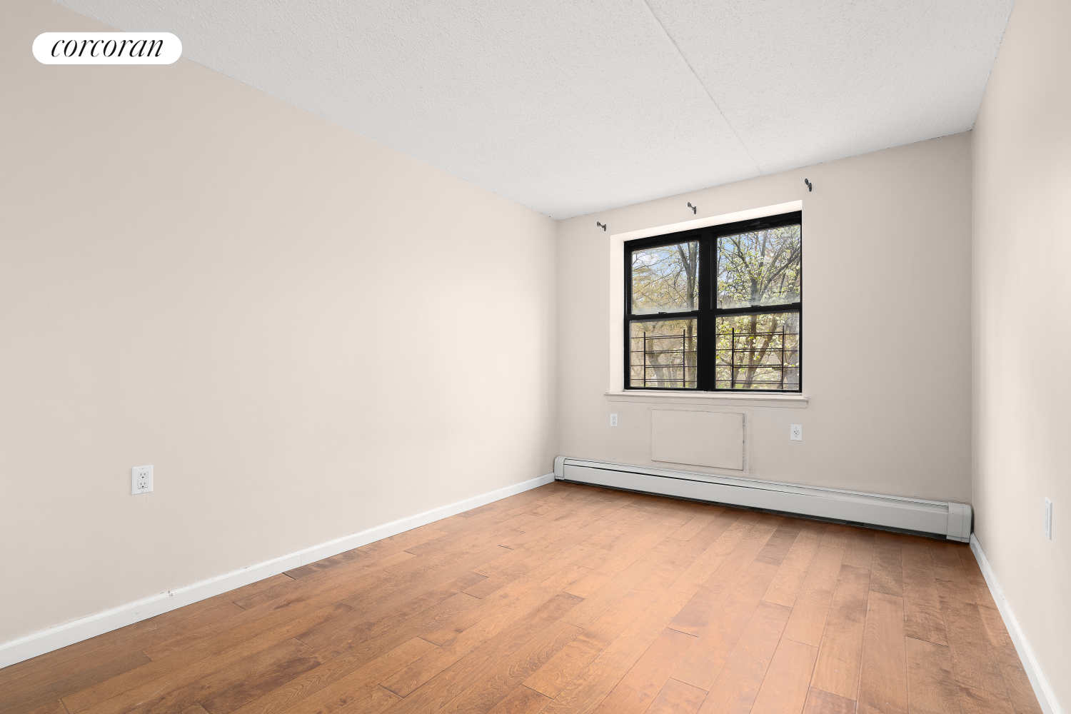 1901 Madison Avenue, Unit 218 Manhattan, NY 10035 - Photo 13 of 13 an empty room with wooden floor and windows
