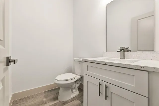 a bathroom with a granite countertop toilet sink and mirror