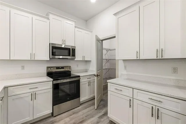a kitchen with white cabinets and white appliances