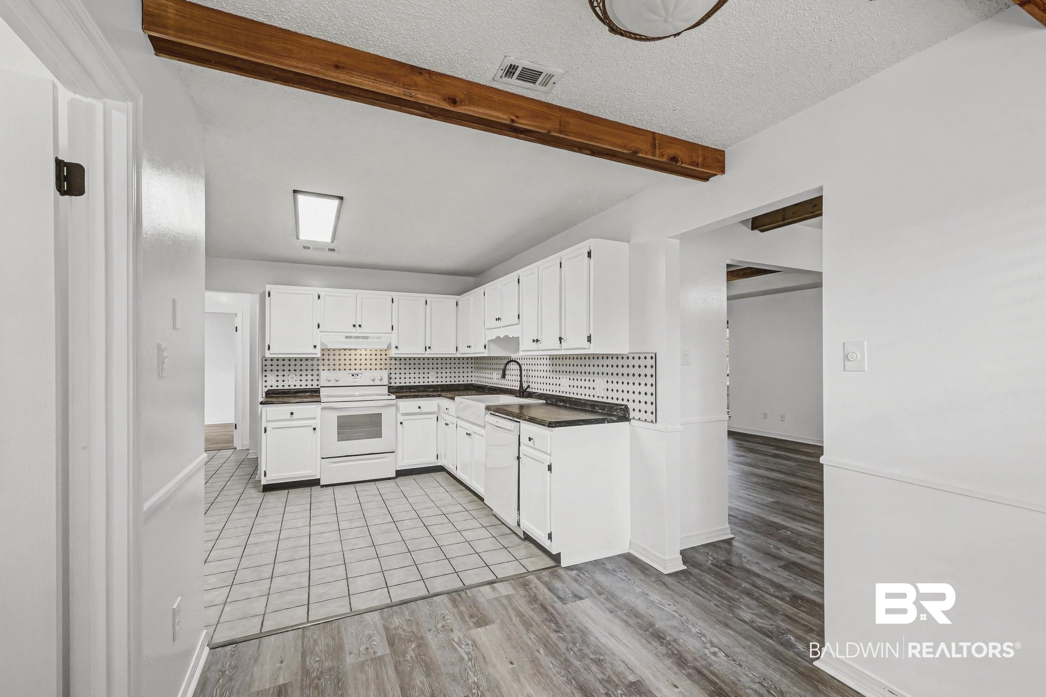 2776 Santa Rosa Circle Lillian, AL 36549 - Photo 11 of 48 Kitchen with dark countertops, white cabinetry, white appliances, backsplash, and beam ceiling