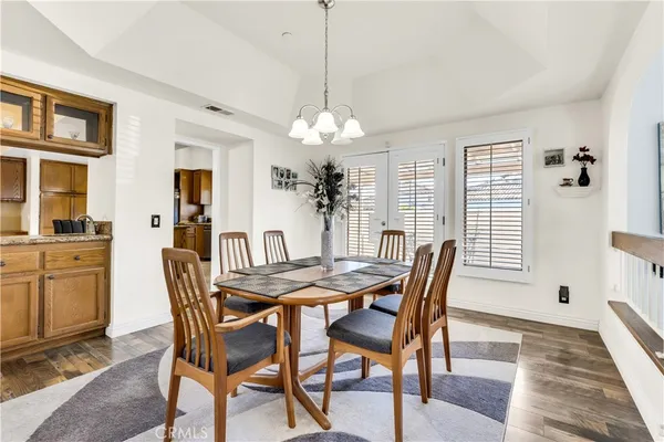 a dining room with furniture a chandelier and wooden floor