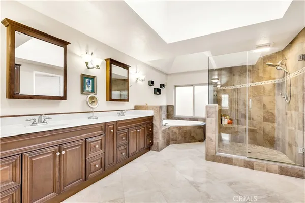 a spacious bathroom with a shower sink and mirror