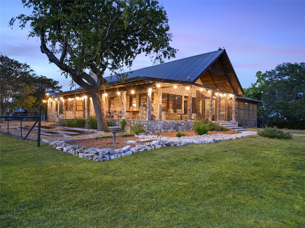 a view of a house with a big yard potted plants and large tree