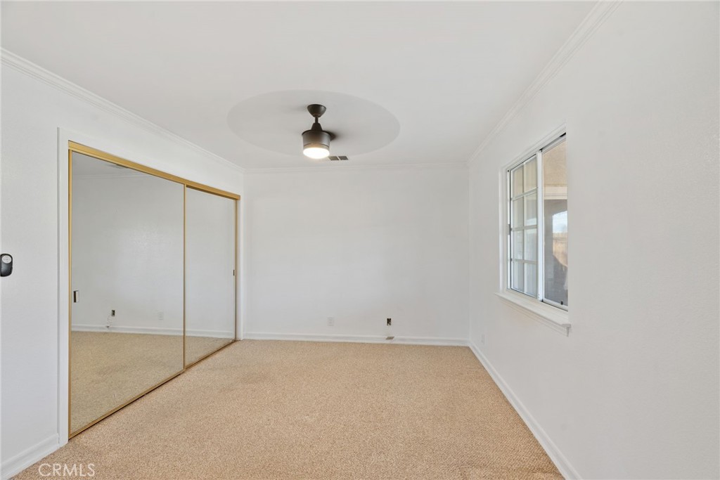 57622 Sierra Way Yucca Valley, CA 92284 - Photo 34 of 75 an empty room with a ceiling fan and a window