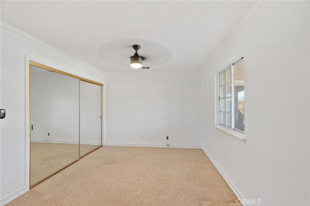57622 Sierra Way Yucca Valley, CA 92284 - Photo 35 of 75 an empty room with a ceiling fan and a window