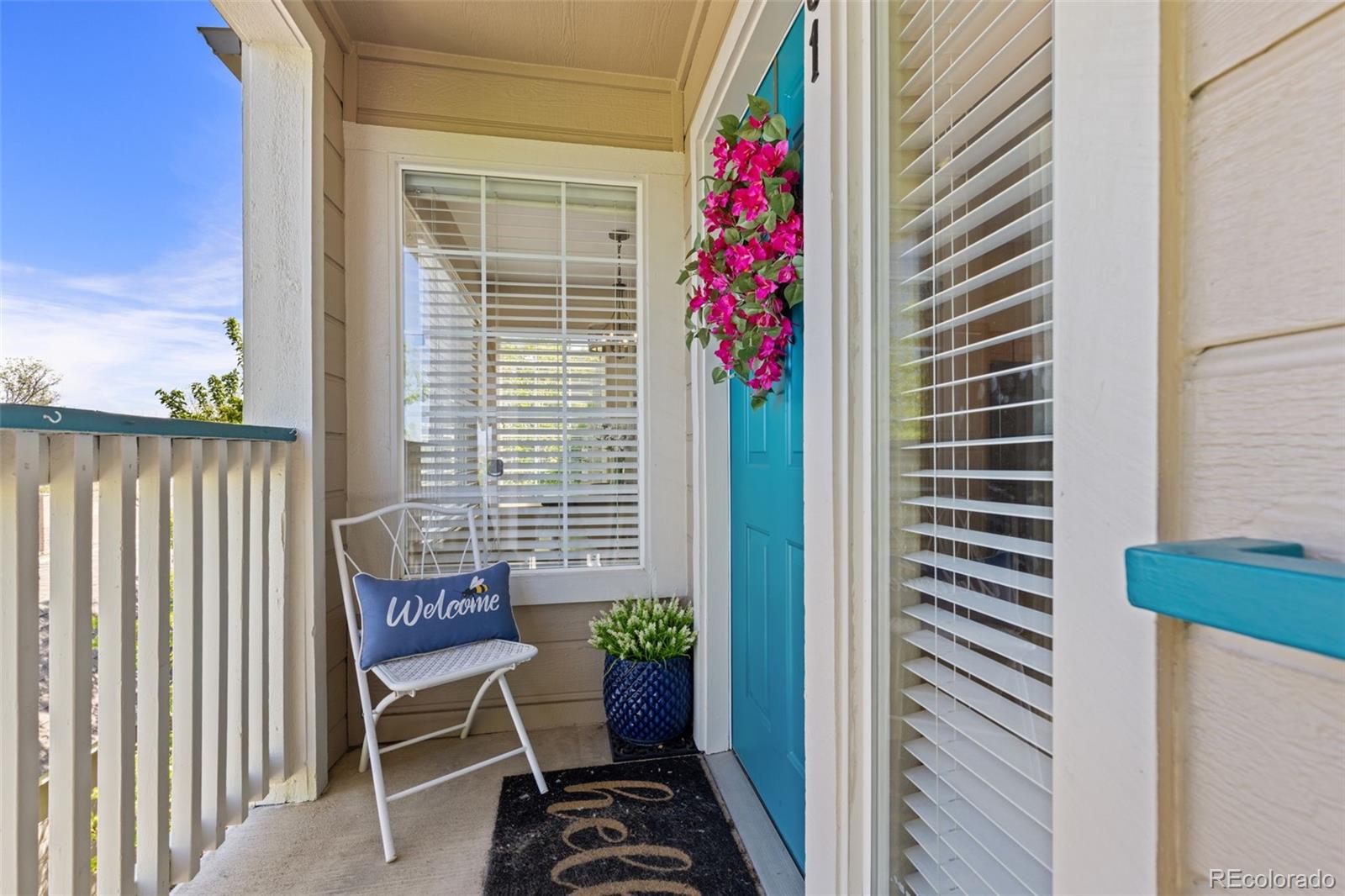 a balcony with table and chairs and potted plants