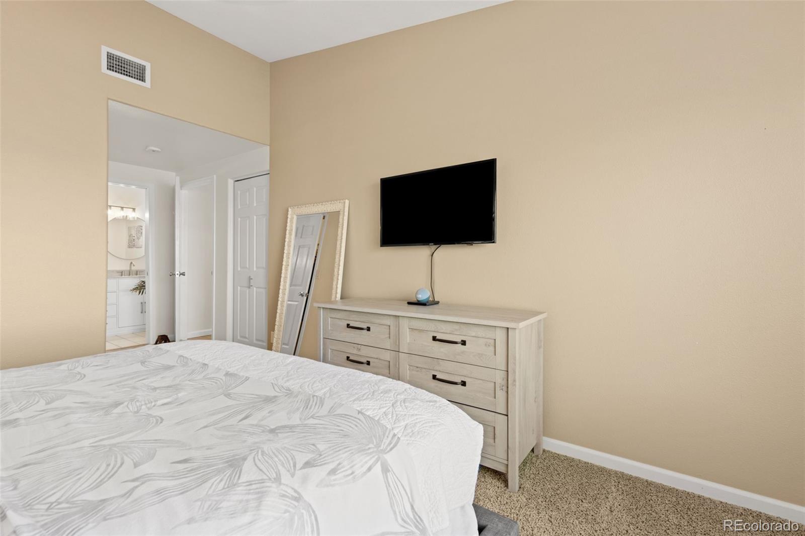 8334 Pebble Creek Way, Unit 201 Highlands Ranch, CO 80126 - Photo 15 of 28 a bedroom with a bed and a flat screen tv