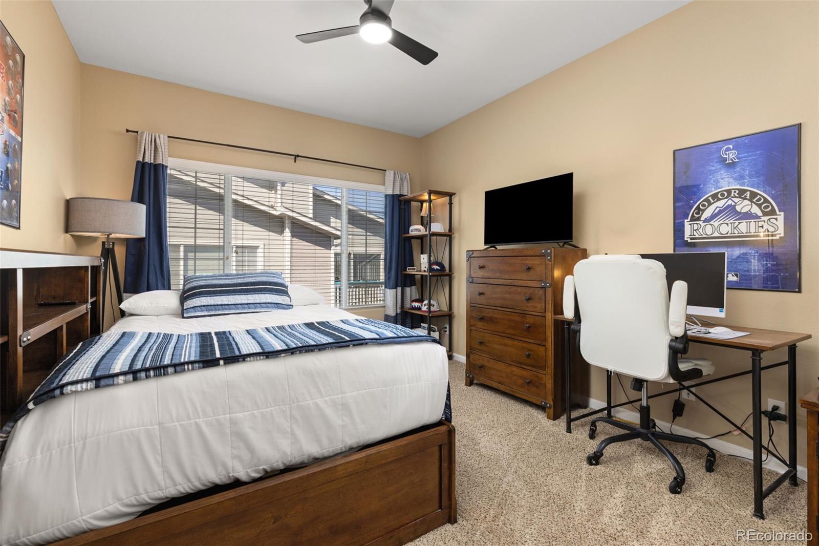 8334 Pebble Creek Way, Unit 201 Highlands Ranch, CO 80126 - Photo 20 of 28 a bedroom with a bed and a flat screen tv